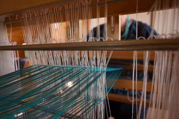 Senior woman weaving silk at shop