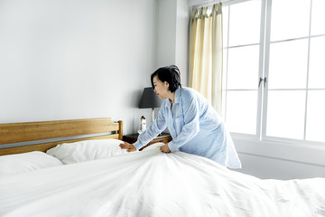 Obraz premium A woman making bed