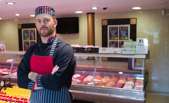 Butcher standing in meat shop with his hands crossed