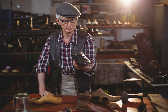 Shoemaker examine a shoe in workshop