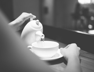 Woman holding a pot and pouring a drink