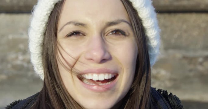 Beautiful woman outdoors in winter smiling and laughing - close up on face
