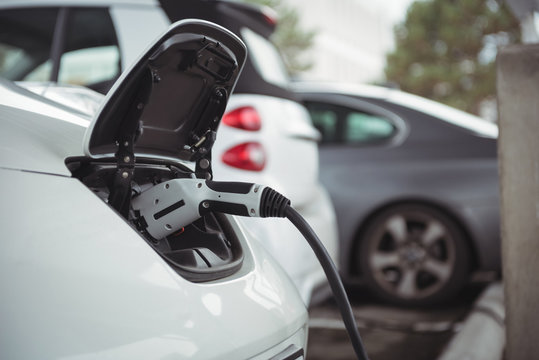 Close-up of car being charged with electric car charger