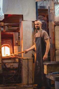 Glassblower heating a glass in furnace