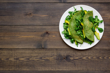 Healthy vegetable pancake. Spinach pancakes on dark wooden background top view copy space
