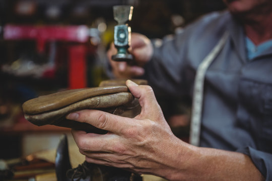 Close up of cobbler hammering on shoe in workshop