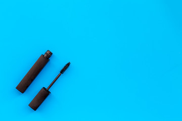Mascara on blue background top view copy space