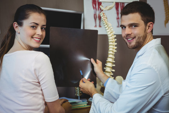Male therapist showing x-ray to female patient