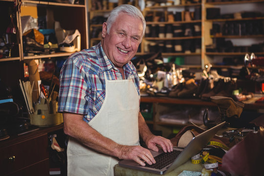Portrait of shoemaker using laptop