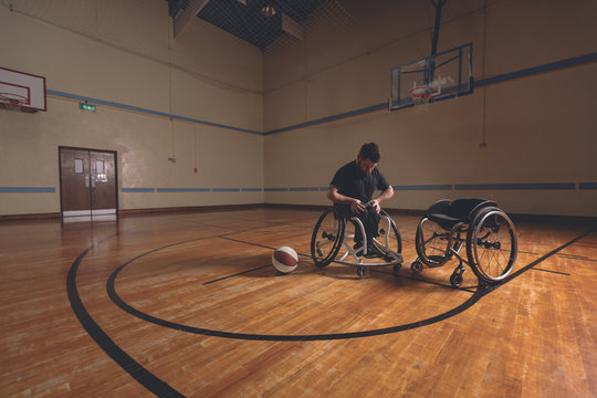 Disabled man adjusting belt of wheelchair