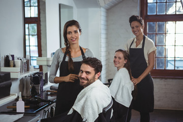 Smiling hairdresser working on the client at the hair salon