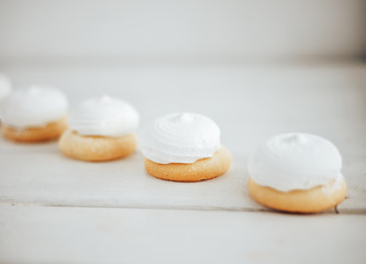 closeup white zephyr cookies lie to the line on white wooden background