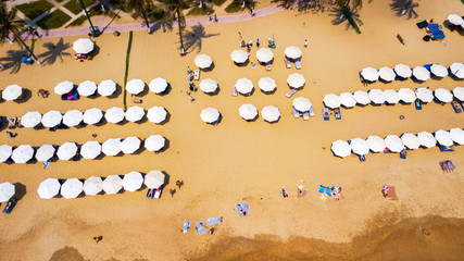 Overhead aerial view of people enjoying the summer at  beach line,waves breaking against the coastal line