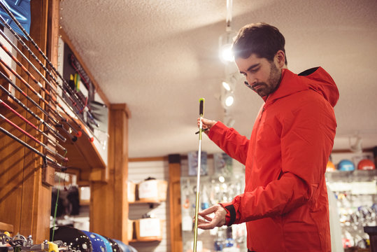 Man holding a ski pole in shop