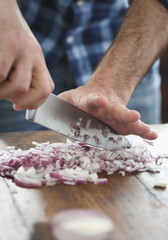 Close up male hands chopped fresh red onion