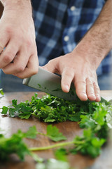 Male hands chopping fresh parsley close up