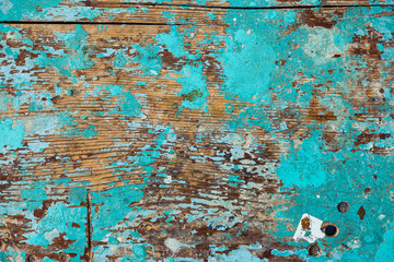 Background image of wooden surface with peeling paint. Old colorful wooden stool close-up. Picturesque texture of table with cracked of surface.