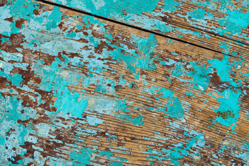 Background image of wooden surface with peeling paint. Old colorful wooden boat close-up. Picturesque texture of vessel fuselage with cracked.