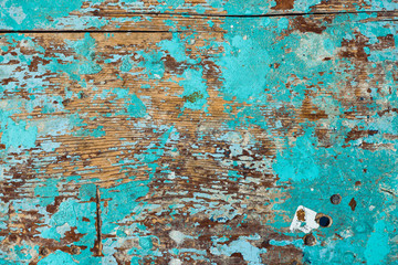 Background image of wooden surface with peeling paint. Old colorful wooden stool close-up. Picturesque texture of table with cracked of surface.