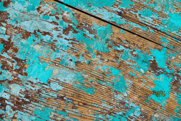 Background image of wooden surface with peeling paint. Old colorful wooden boat close-up. Picturesque texture of vessel fuselage with cracked.