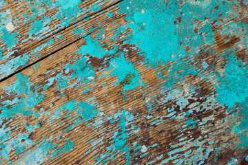 Background image of wooden surface with peeling paint. Old colorful wooden boat close-up. Picturesque texture of vessel fuselage with cracked.