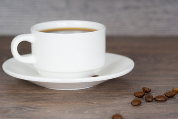 coffee cup with coffee beans on wooden table