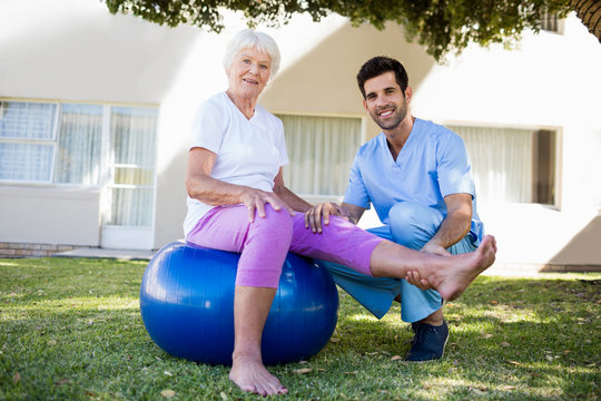 Nurse helping senior woman doing exercises 
