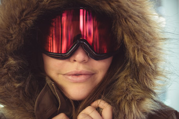 Young woman in ski goggles and fur coat