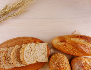 Various breads on wooden plate and beige wooden background with copy space Food,bakery concept