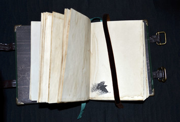 Handmade ancient-looking notebook  with a raven in a lower left corner