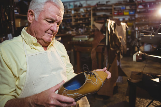Shoemaker examining a shoe
