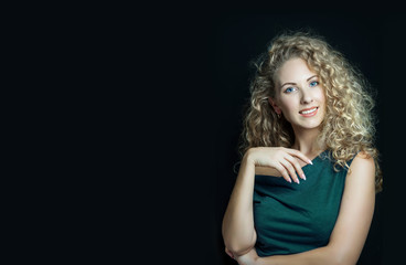 Fototapeta premium Blonde girl with long and shiny curly hair . Beautiful pretty woman model with curly hairstyle . Copy space for your text