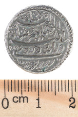 An ancient silver Indian rupee depicting two fishes. Reverse. Isolated on white