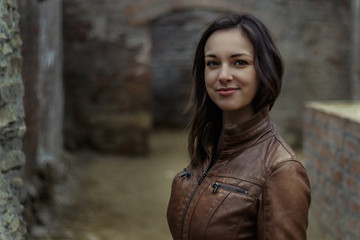 portrait of a young woman in brown leather jacket outside - 200197653