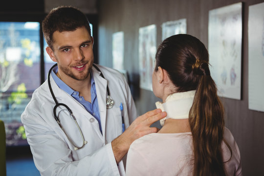 Physiotherapist examining a female patient's neck