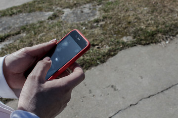 women is holding a phone against the background of the grass