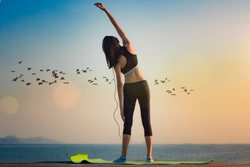 young woman sport exercise practice on wooden bridge in the sea at sunset, relax and comfortable in place