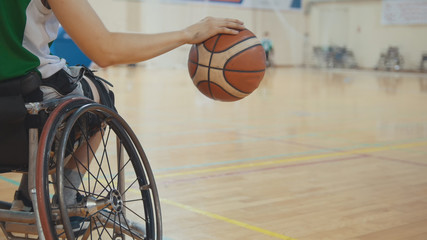 Fototapety  Koszykarz na wózku inwalidzkim szybko kozłujący piłkę podczas treningu niepełnosprawnych sportowców