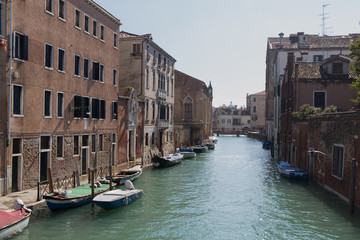 Empty Venetian street water canal with boats and old buildings 