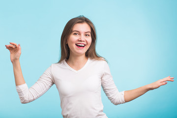 Energy girl dances on blue background in studio.