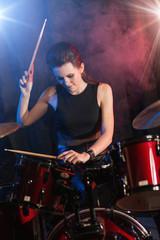 Fototapeta na wymiar Young woman playing drums