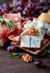 Prosciutto with various cheeses , grapes and  walnuts .