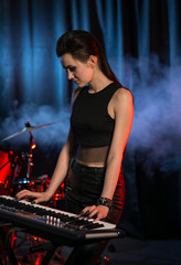 Obraz na płótnie Canvas Female keyboards player in studio