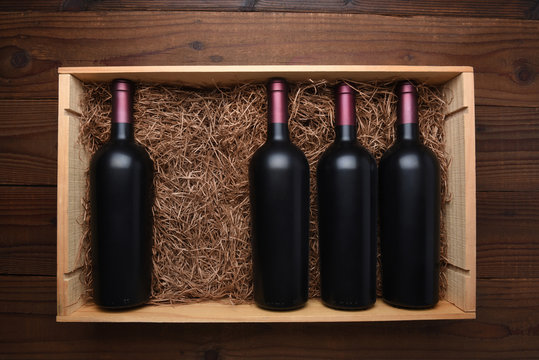 Wood case of red wine bottles with one missing