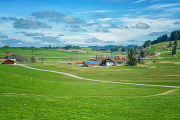 Fototapeta na wymiar Mountains, green field and house with blue sky, beautiful countryside landscape in Switzerland
