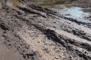 Tractor tracks in mud on a clay field in the spring.