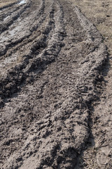 Tractor tracks in mud on a clay field in the spring.