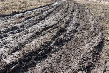 Tractor tracks in mud on a clay field in the spring.