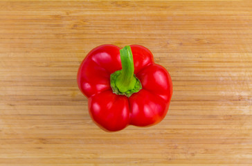 Red bell pepper on cutting board, top view