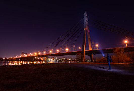 Night city. Beautiful glowing bridge over the river